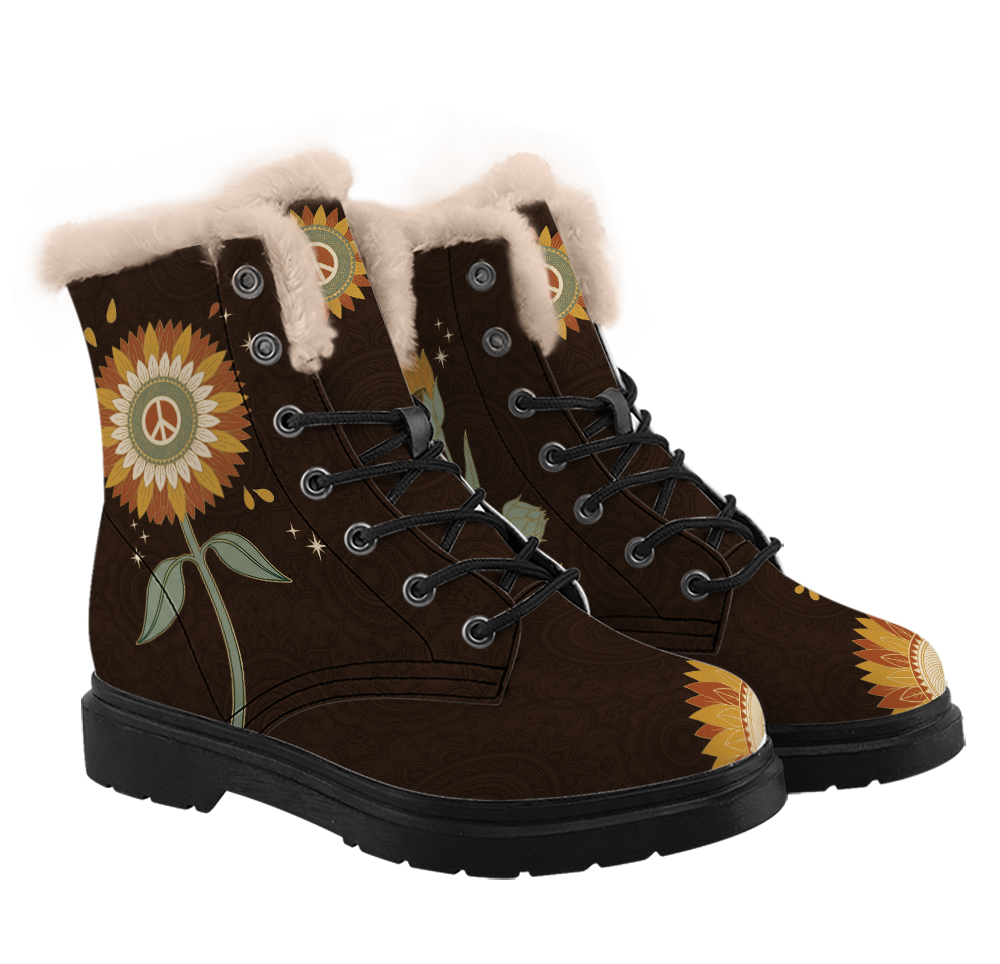 Sunny Winter Boots mockup - three-quarter view of the pair, pale blush-cream plush trim at each collar, a large rust and gold sunflower with a sage centre and cream peace sign halfway up one shaft, its sage stem and two leaves below it, two closed studs then five open eyelets with black laces, half sunflowers over both toes