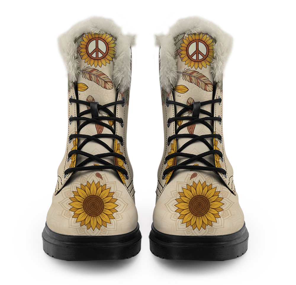 Joni Winter Boots mockup - the pair straight on from the front, pale plush pile ringing each collar, a sunflower with a peace sign at the top of each tongue, striped feathers and an amber leaf below it, black laces crossing down five eyelets, and a big gold sunflower on a cream ground across each round toe.