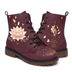 Lotus Leather Boots — studio shot on white with both faces visible, a large cream and blush lotus flanked by sage leaf sprays on one boot, a smaller lotus standing on a gold unalome on the other, deep wine upper