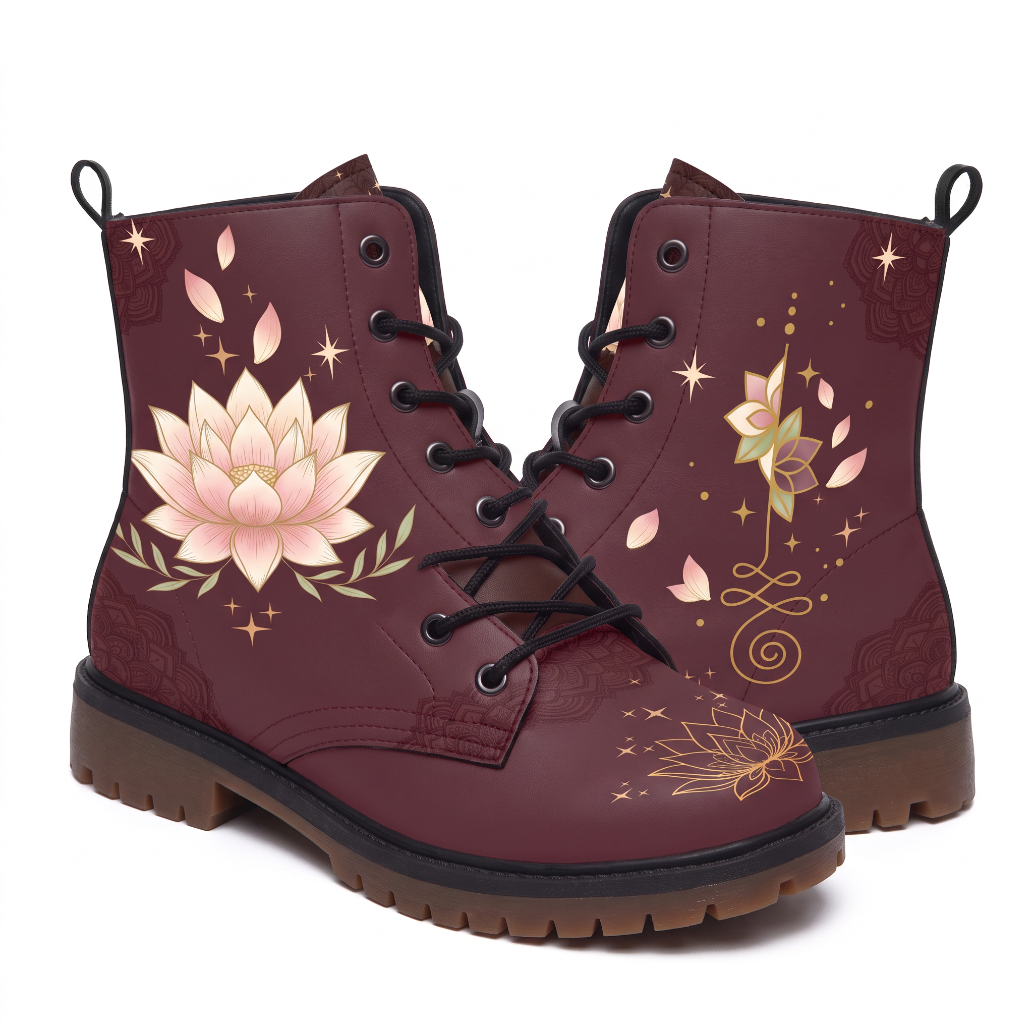 Lotus Leather Boots — studio shot on white with both faces visible, a large cream and blush lotus flanked by sage leaf sprays on one boot, a smaller lotus standing on a gold unalome on the other, deep wine upper
