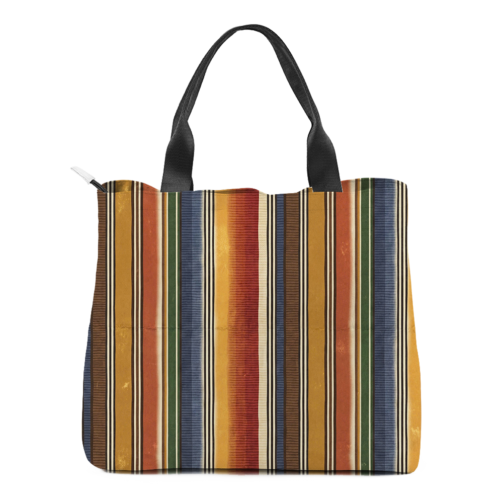 Sedona tote bag square to the camera, the striped face flat and the bands running unbroken from the top hem down to the base; black webbing handles rise in a V, the pale zip pull sits at the top left corner, and a dark shadow lies under the bag.